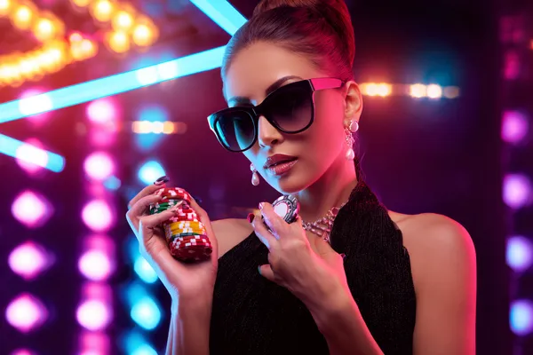 A young woman relaxing with her phone while dynamic casino elements float around her, illustrating the smooth mobile experience offered by the 9777 app.
