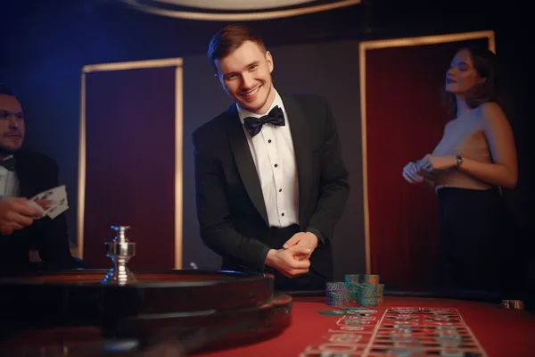 A cheerful woman in traditional clothing using her smartphone during a festive moment, showing how easily the 9777 app fits into everyday life.